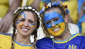 Mit Blumen im Haar und einem freundlichen Lächeln begrüßen diese beiden ukrainischen Fans Europa